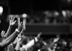 Saboori Black and white image of audience with hands raised, capturing concert energy.
